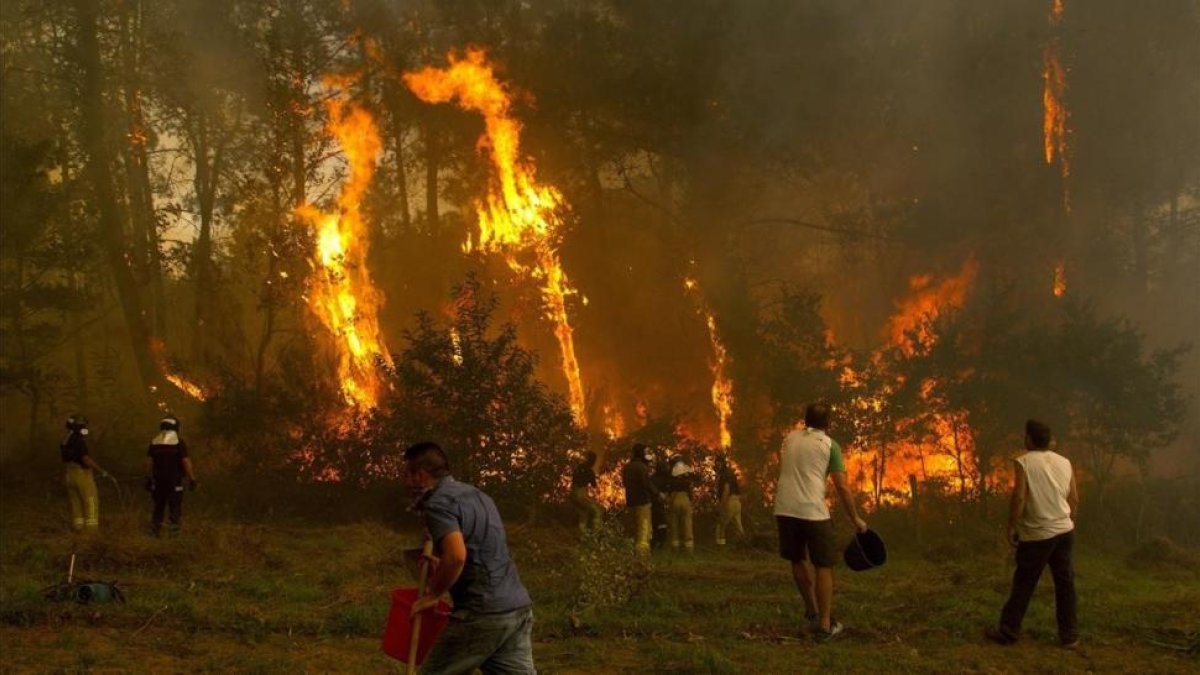 Un grupo de vecinos trabaja en el incendio en la zona de Zamanes, cerca de Vigo.-EFE / SALVADOR SAS