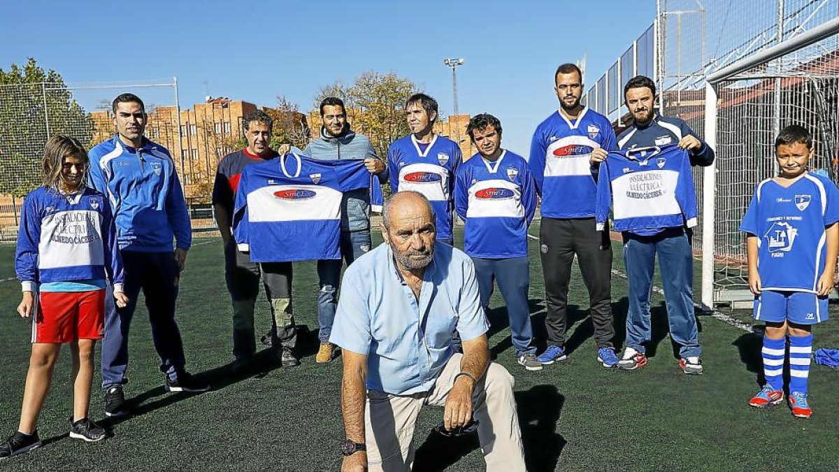 Demetrio Nieto posa con un balón sobre el césped con varios jugadores de diferentes generaciones que han pasado por el club de Pajarillos durante su presidencia.-J. M. LOSTAU