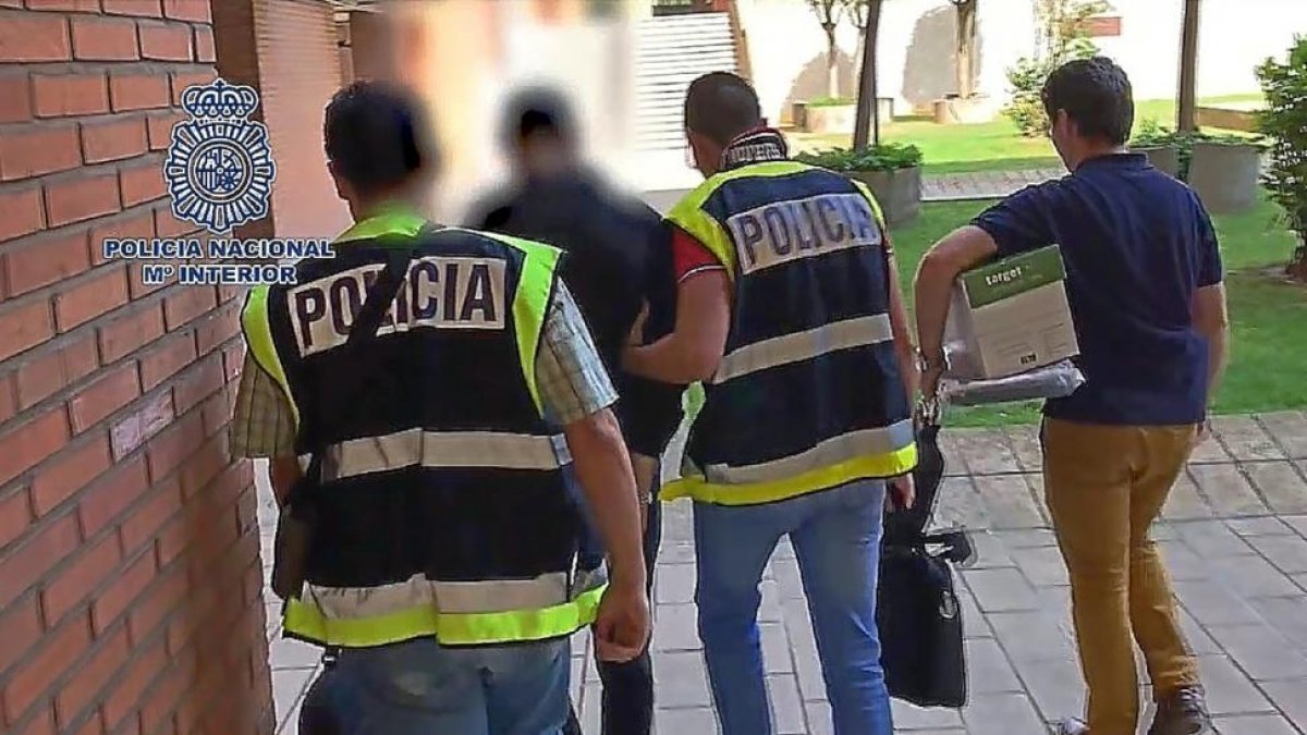 Policías de Valladolid salen del registro del domicilio  del británico , con dos portátiles y una caja de documentos.-E. M.