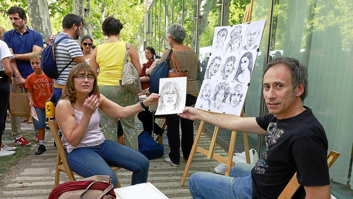 María Barrio enseña el dibujo que le ha hecho el pintor Julio Sendino en Recoletos.-J. M. LOSTAU