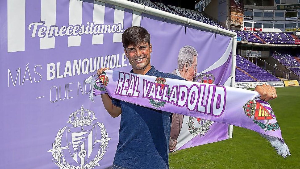 Markel Etxeberria posa con la bufanda del Real Valladolid ante el cartel promocional de la campaña de abonos.-PABLO REQUEJO