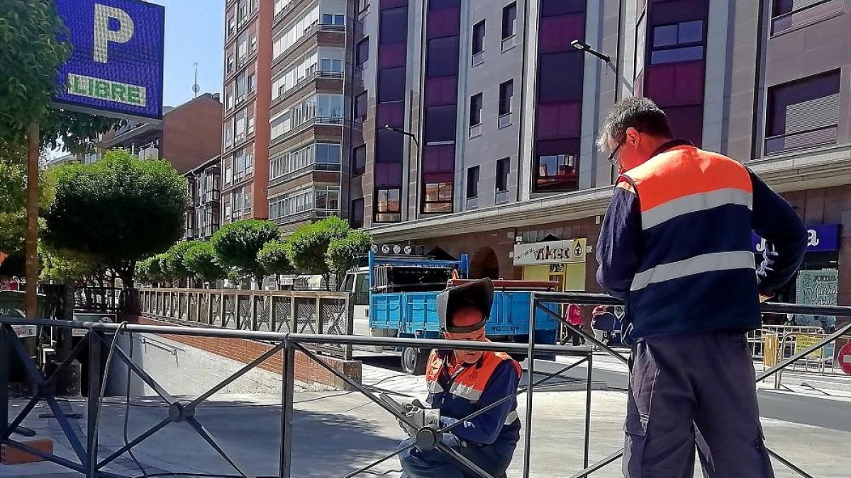 Dos operarios ultiman los detalles del primer tramo de la calle Panaderos abierto al tráfico.-J.M. LOSTAU