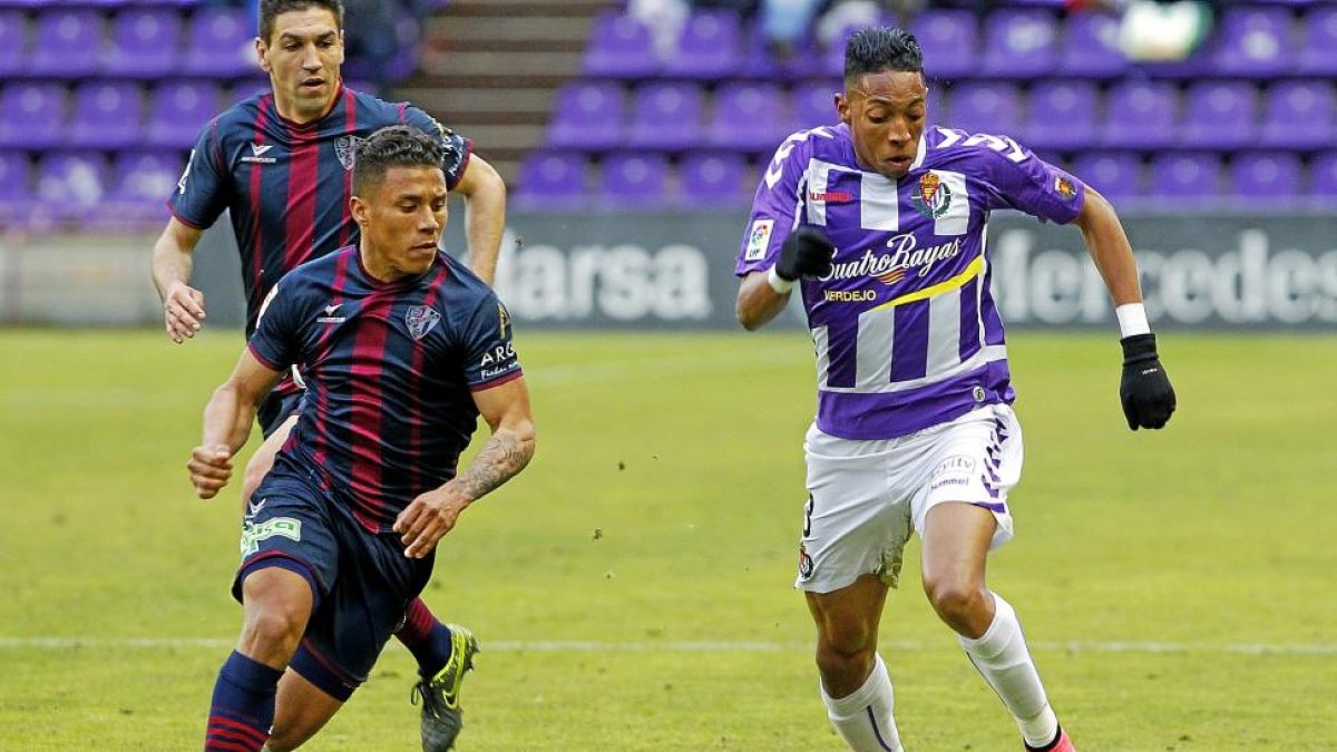 Mojica avanza con el balón ante el Huesca, con pequeños trozos de césped por el aire.-J.M.LOSTAU