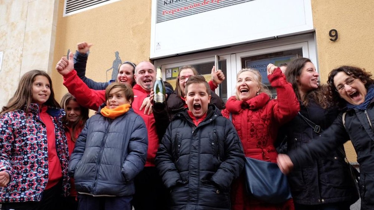 Alumnos y padres agraciados con el Gordo a las puertas de las instalaciones de la Escuela de Judo Seiza, ubicada en la calle Filipinas de Salamanca.-ICAL