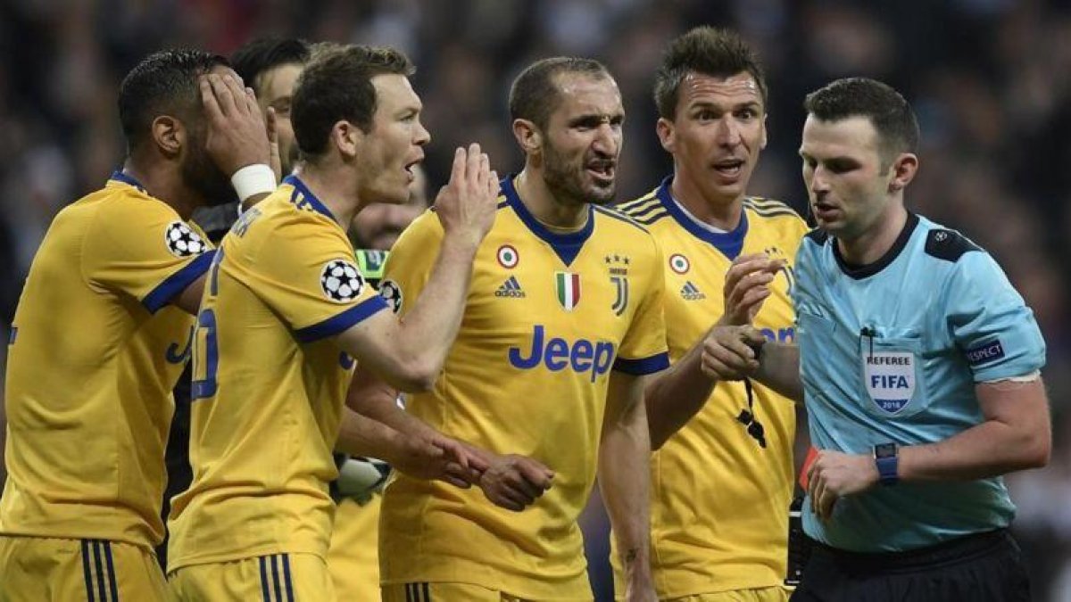 Los jugadores de la Juventus rodean al árbitro tras el polémico penalti.-AFP / OSCAR DEL POZO