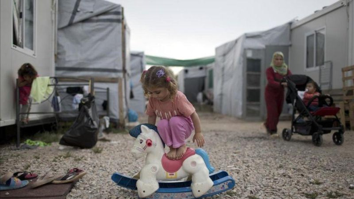Una niña siria juega en un campo de refugiados griego.-PETROS GIANNAKOURIS (AP)