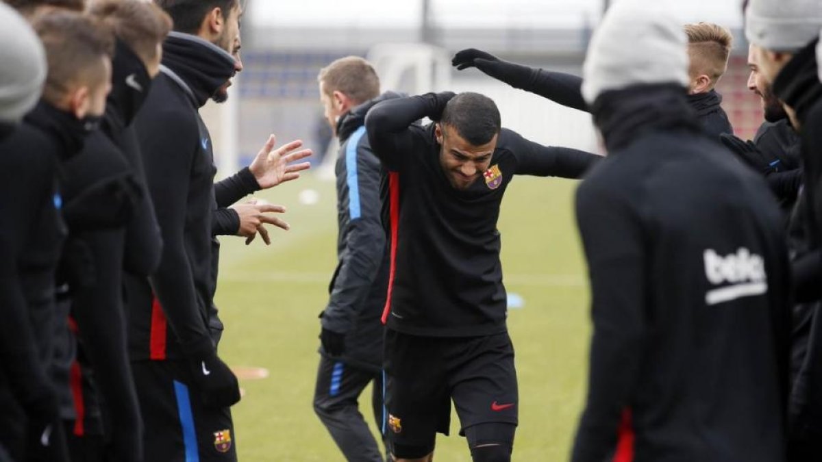 Los jugadores del Barça saludan a Rafinha, en su regreso a los entrenamientos.-EL PERIÓDICO