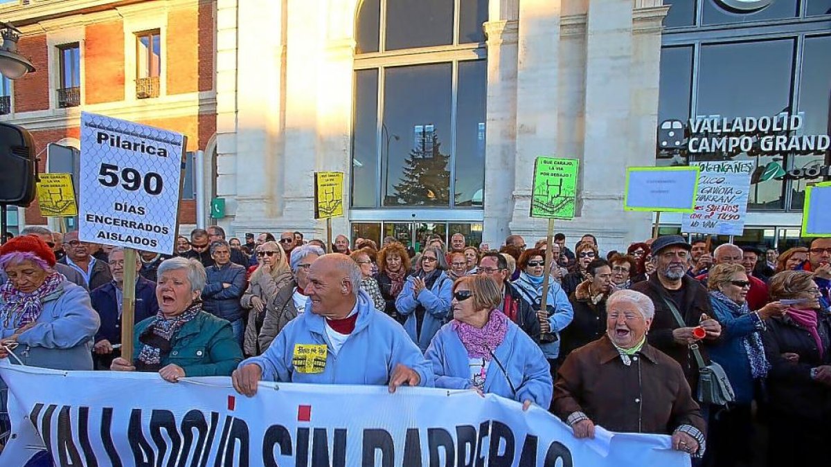 Los manifestantes de Pilarica portan la pancarta y carteles para recordar los 590 días desde que se cerró el paso a nivel.-ICAL