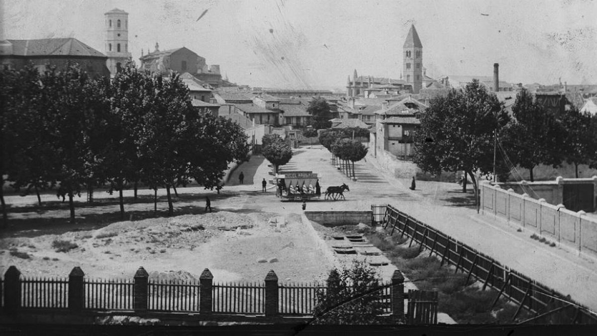 Las torres de la seo y de La Antigua, al fondo, vistas desde un tramo de la calle Paraíso con una parte ya cubierta del Esgueva, en una imagen tomada hacia 1910.-ARCHIVO MUNICIPAL DE VALLADOLID