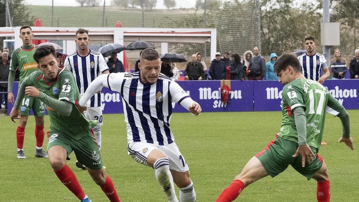 El defensa central Alende sale con el balón jugado, entre dos rivales.-NURIA MONGIL