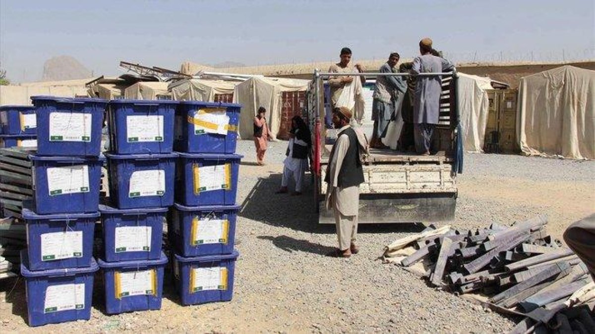 Varios trabajadores transportan urnas a un colegio electoral en Kandahar, este viernes.-MUHAMMAD SADIQ (EFE)