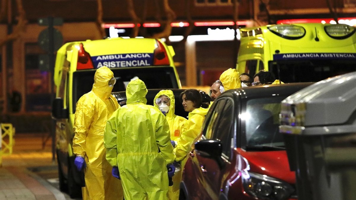 Personal sanitario, equipado con máscaras y trajes especiales, en la calle Italia. - J.M. LOSTAU
