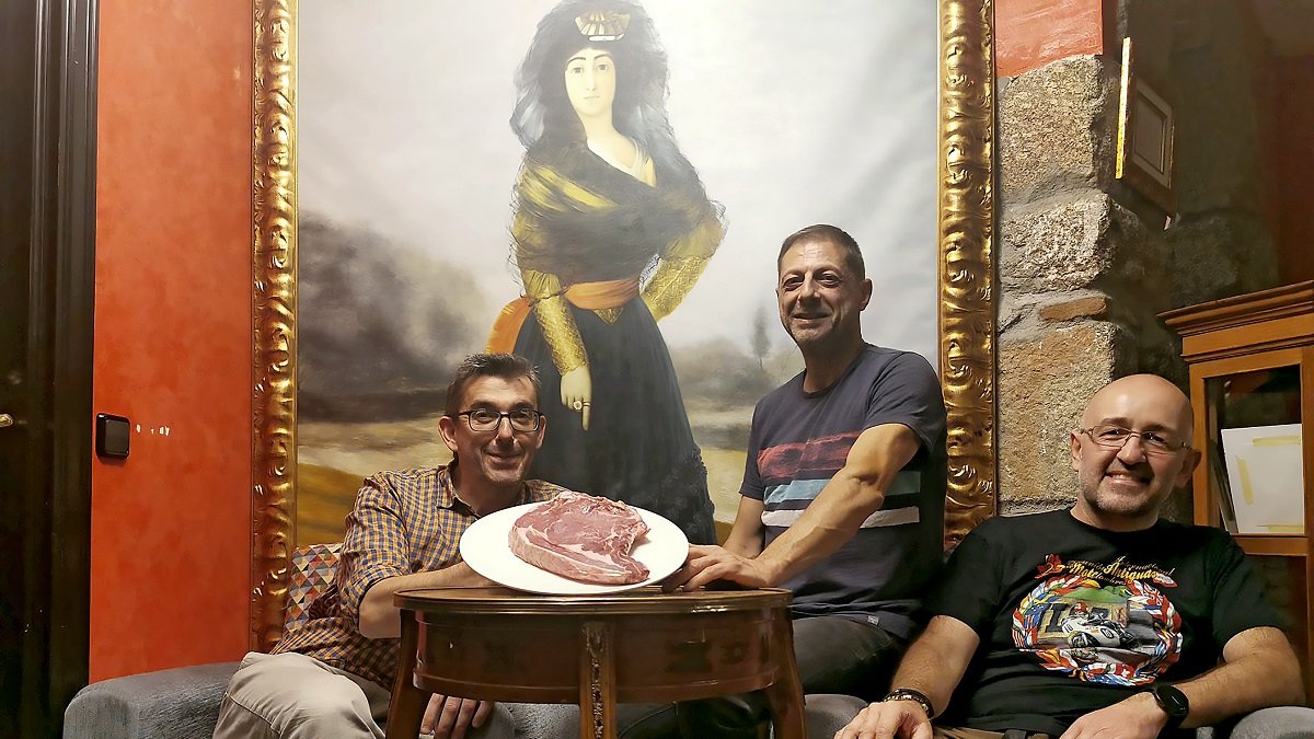 Julio, Antonio y Suso, frente a un retrato de Cayetana de Alba, en su restaurante de Piedrahíta.