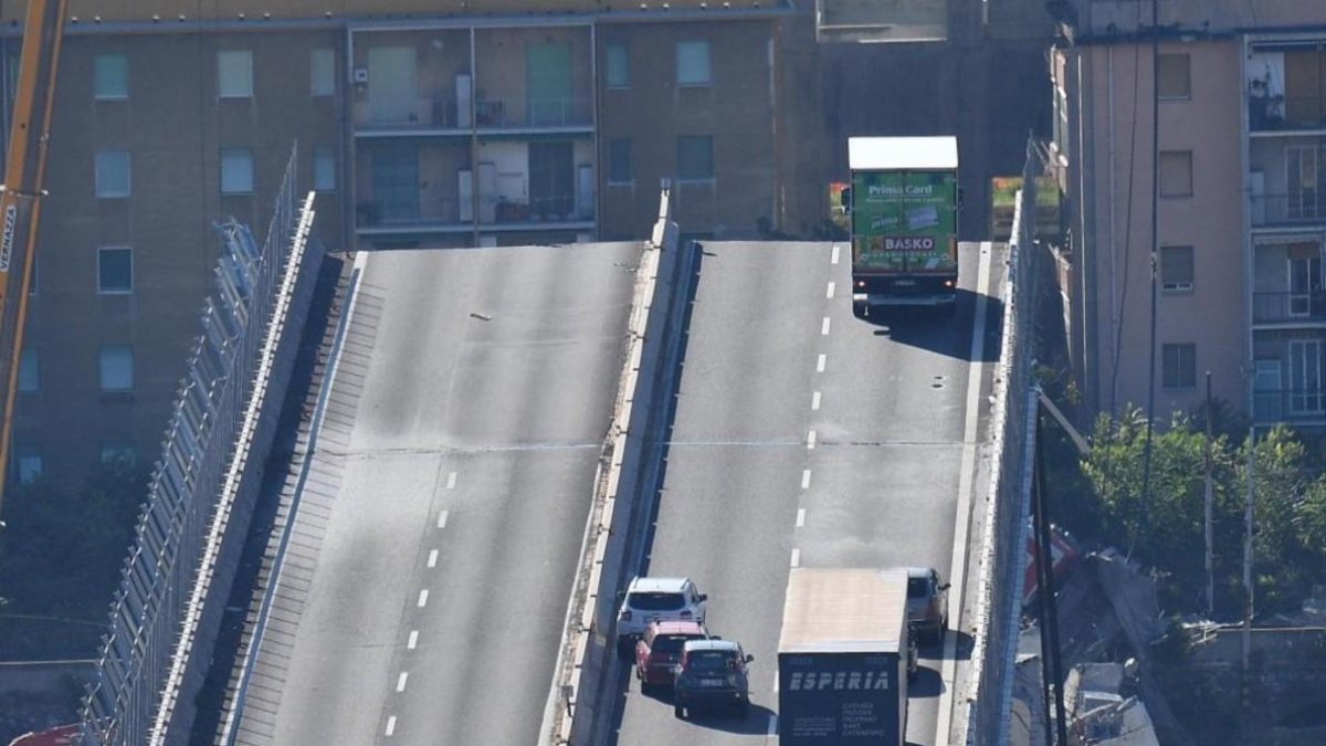 Un camión permanece al borde de la sección que continúa en pie del puente Morandi.-