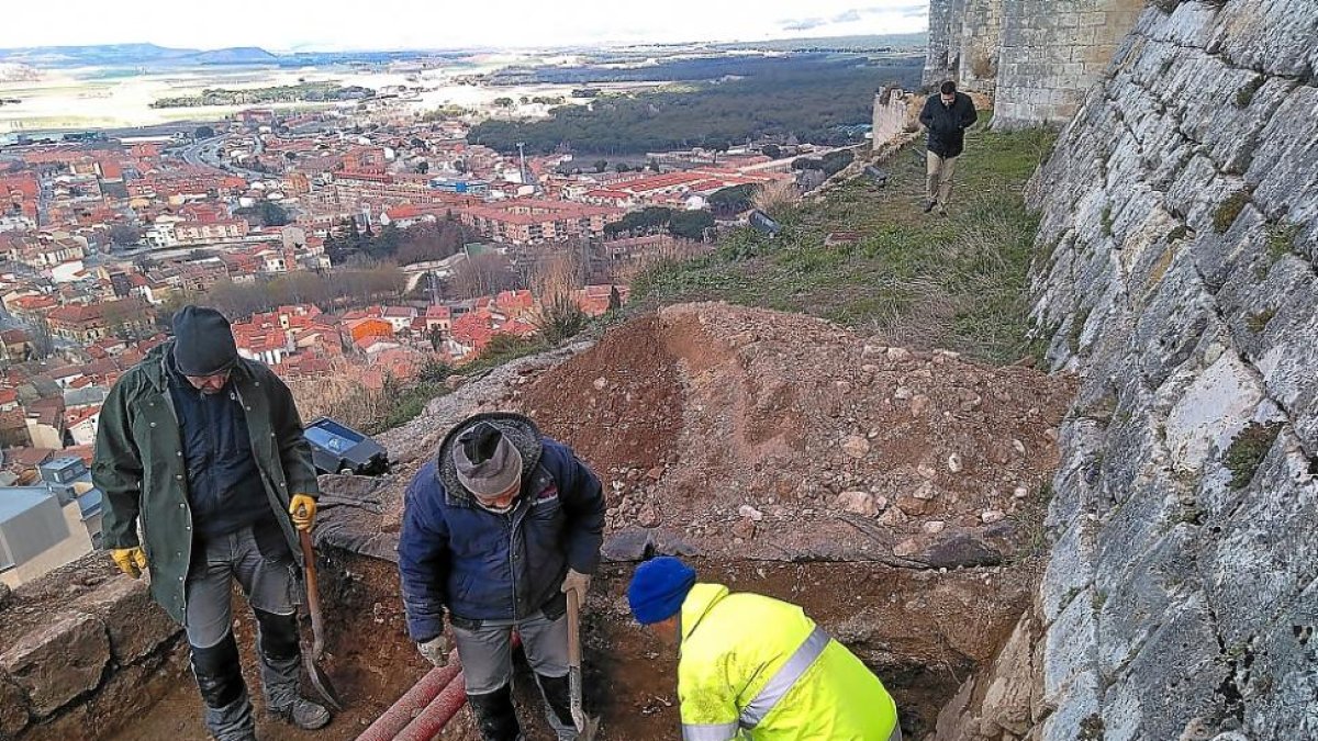 Varios operarios trabajan en una de las catas realizadas en el perímetro, con el alcalde de Peñafiel, Roberto Díez, al fondo.-L.G.E.