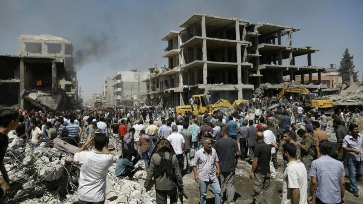 Sirios observan la destrucción tras el doble ataque en Qameshli, el 27 de julio.-AFP / DELIL SOULEIMAN