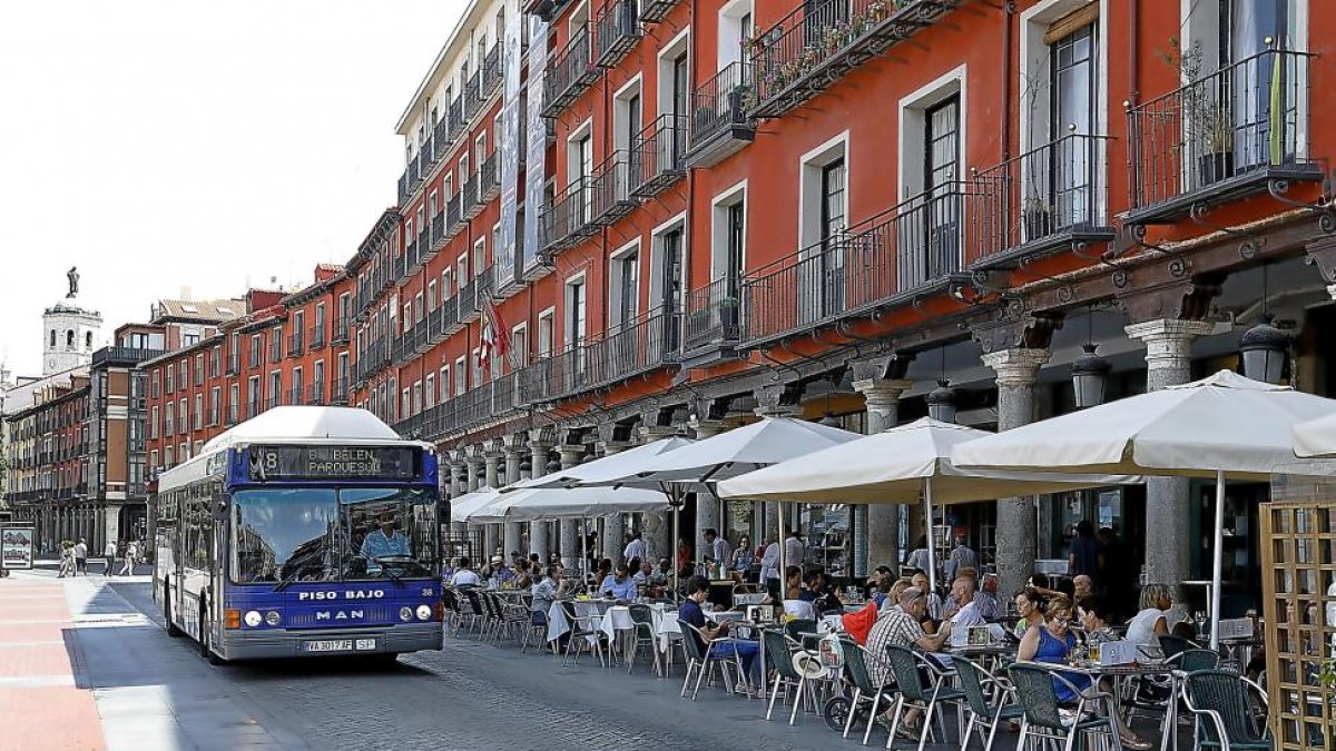 Un autobús circula por la Plaza Mayor junto al público sentado en las terrazas.-J. M. LOSTAU