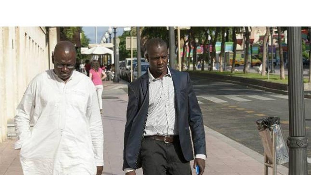Ibrahim Sylla (derecha), hermano del mantero fallecido en Salou, a su entrada en los juzgados de Tarragona.-Foto: XAVI MOLINER