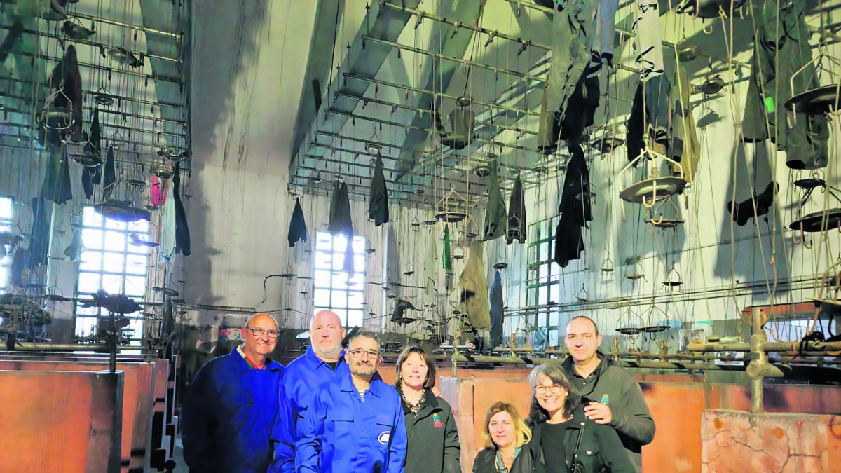 En la fotografía, la alcaldesa de Fabero junto a la Asociación de Mineros que se ha implicado en todo momento como guías turísticos, contando, en primera persona a los visitantes su experiencia en las entrañas de la tierra. En la visita podemos contemplar la imagen sobrecogedora de los monos colgados del último turno de trabajo. / LA POSADA