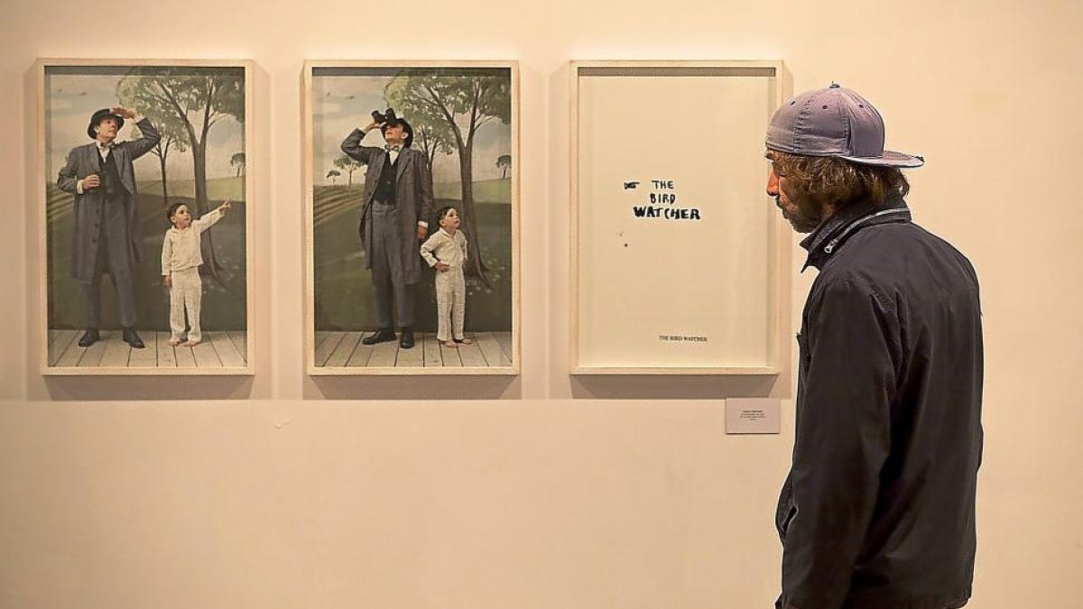 Un hombre contempla dos fotografías de la serie ‘The bird watcher’, en San Benito.-PABLO REQUEJO
