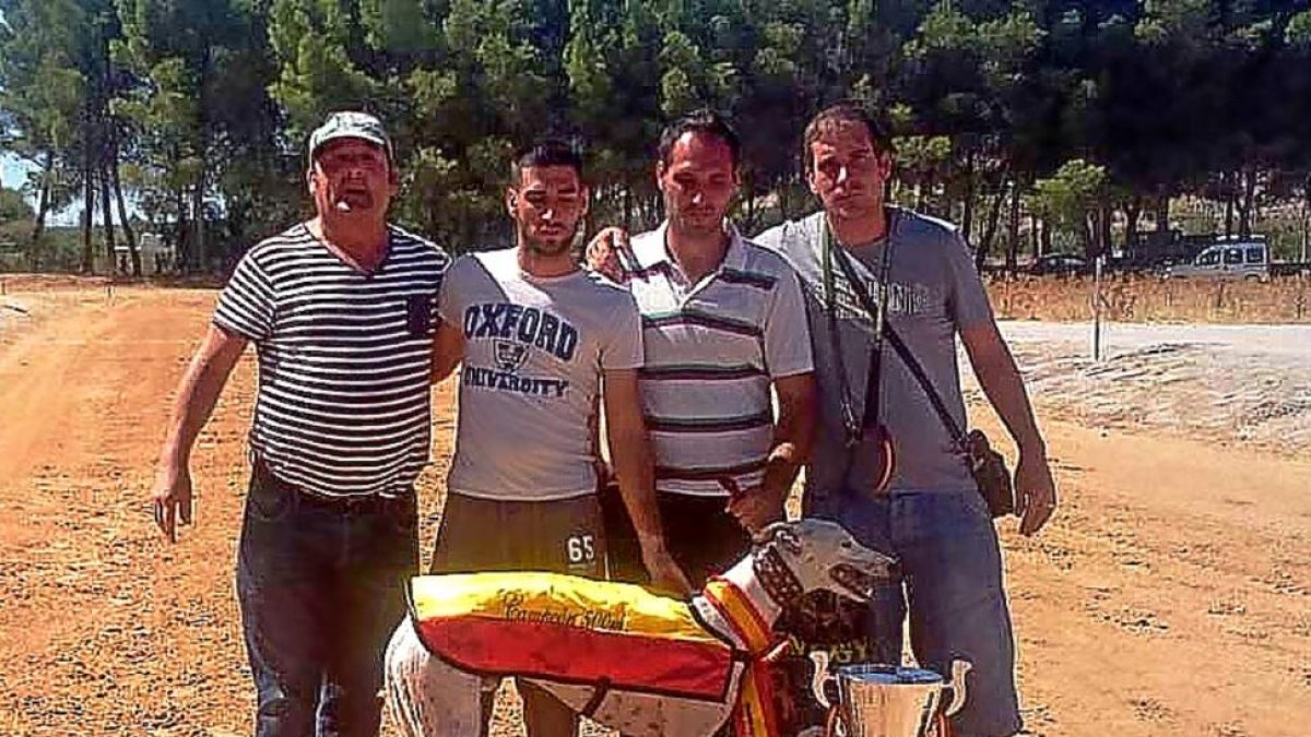 Los propietarios de Speed, con la Copa de campeón de España de galgos en recta.-LEONARDO DE LA FUENTE