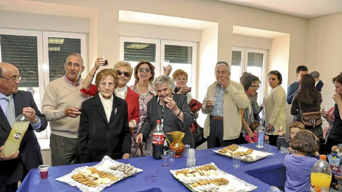Las ‘abuelas’ del pueblo, Baltasara (99 años)y Alejandra (88), con familiares, ayer, comen el ‘bollo’.-Santiago