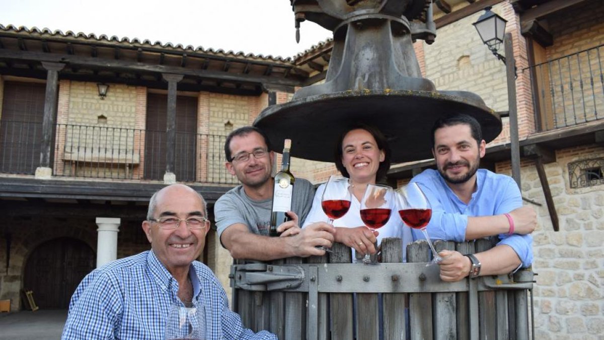 Los hermanos Alfredo, Inés y Pablo (de izquierda a derecha), dentro de una antigua prensa, junto a su padre Alfredo.-ARGICOMUNICACIÓN