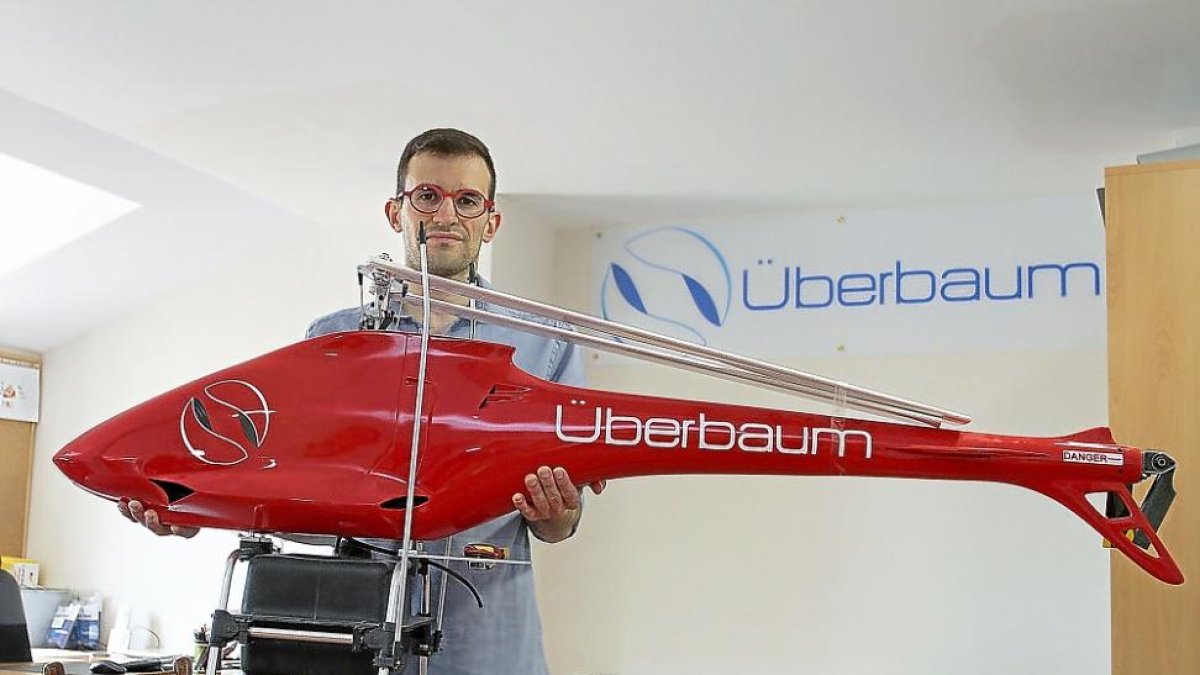Miguel Sanz Vidal muestra el helicóptero fumigador que construye la empresa palentina Überbaum.-MANUEL BRÁGIMO.