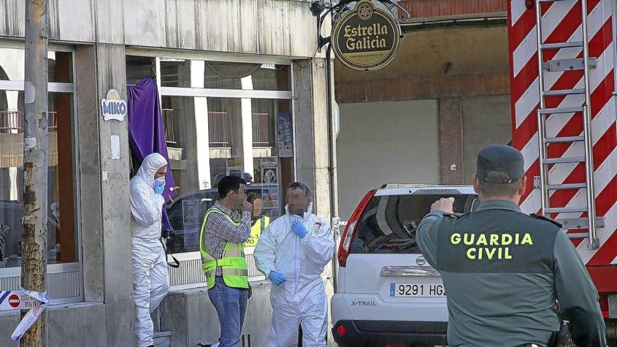 Guardia Civil y agentes de la Policía Científica en el bar donde apareció muerto el agresor de la mujer asesinada en Guardo.-ICAL