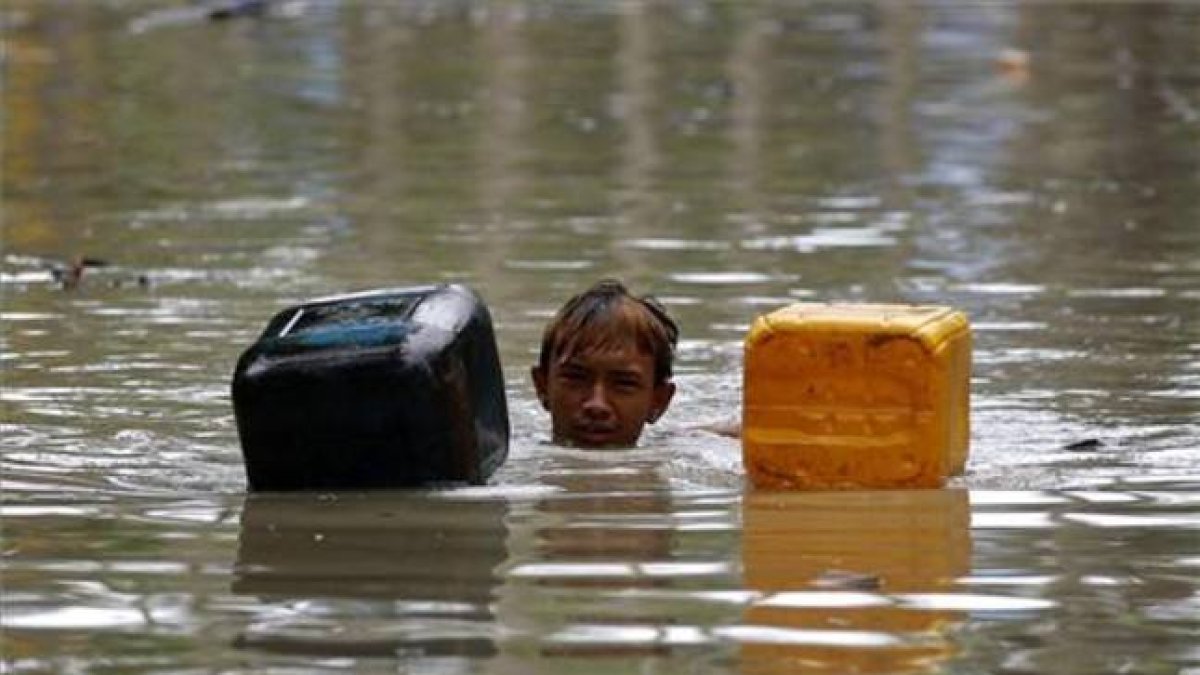 Uno de los miles de afectados por las lluvias torrenciales que han afectado a Birmania espera la llegada de los efectivos de rescate.-Foto: EFE / LYNN BO BO