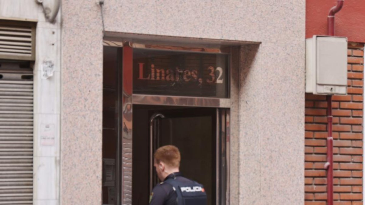 Un policía entra en el domicilio de la calle Linares en Rondilla, donde eran asesinadas la madre y la hija este sábado. PHOTOGENIC