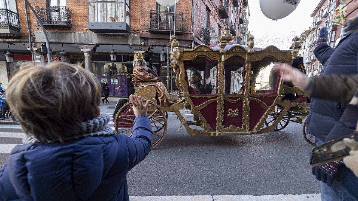 Un niño saluda a los Reyes Magos al paso de la carroza en su calle casi sin gente, el 5 de enero. PABLO REQUEJO / PHOTOGENIC