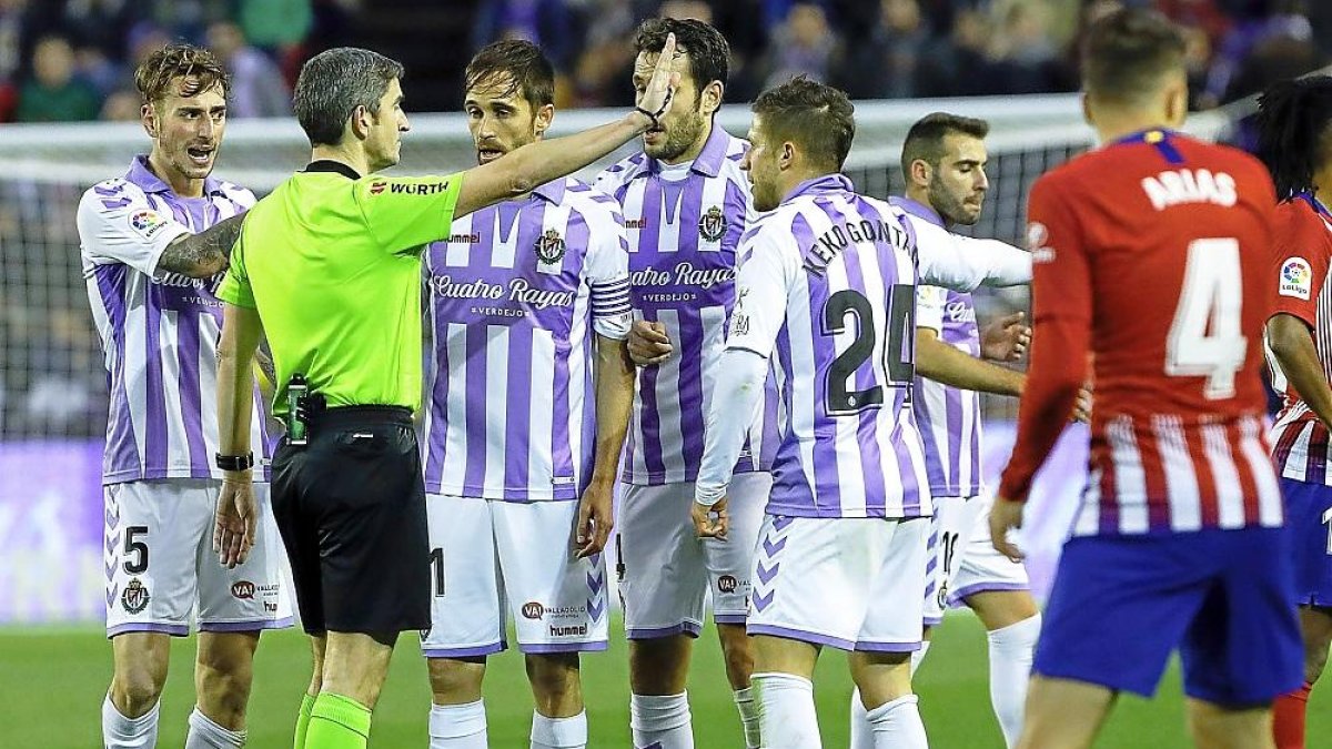 Varios jugadores del Real Valladolid reclaman a Undiano Mallenco.-J.M. LOSTAU