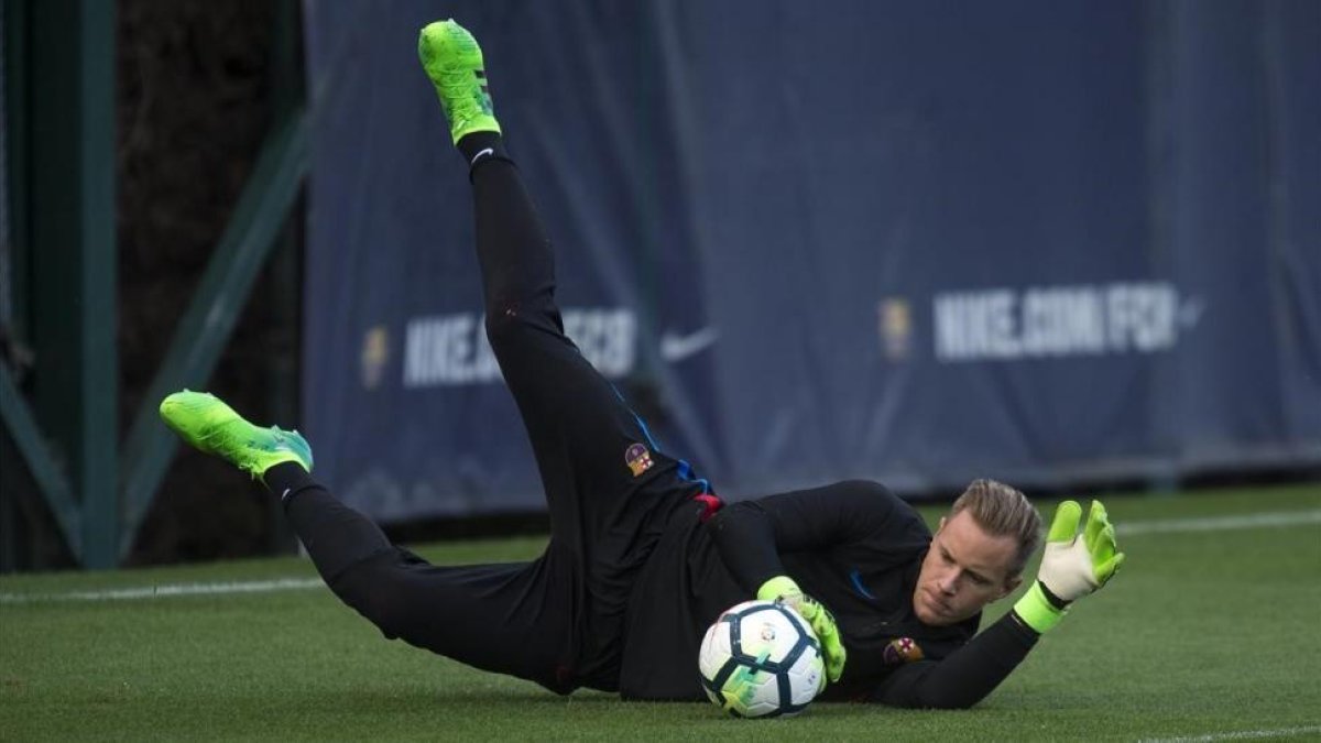 Ter Stegen atrapa el balón en un entrenamiento en la ciudad deportiva del Barça.-JORDI COTRINA