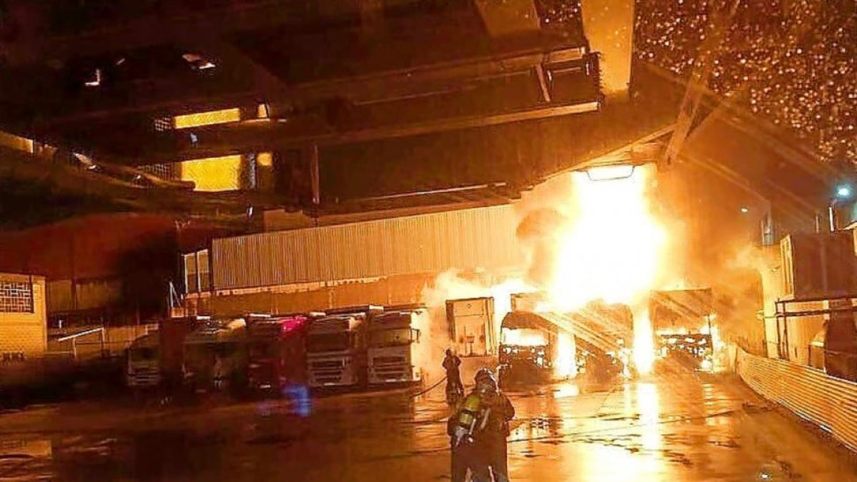 Imagen de los Bomberos en pleno incendio de los camiones.-E.M.