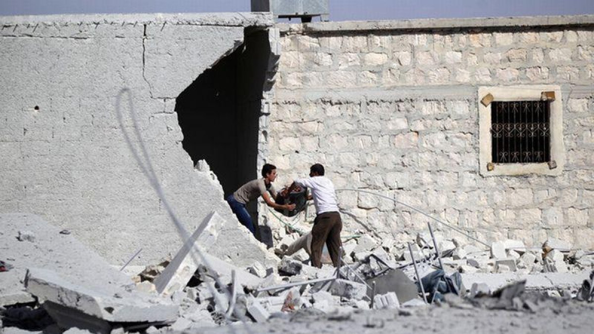 Civiles sacan sus pertenencias de su vivienda bombardeada en una localidad de los alrededores de Alepo.-KHALIL ASHAWI / REUTERS