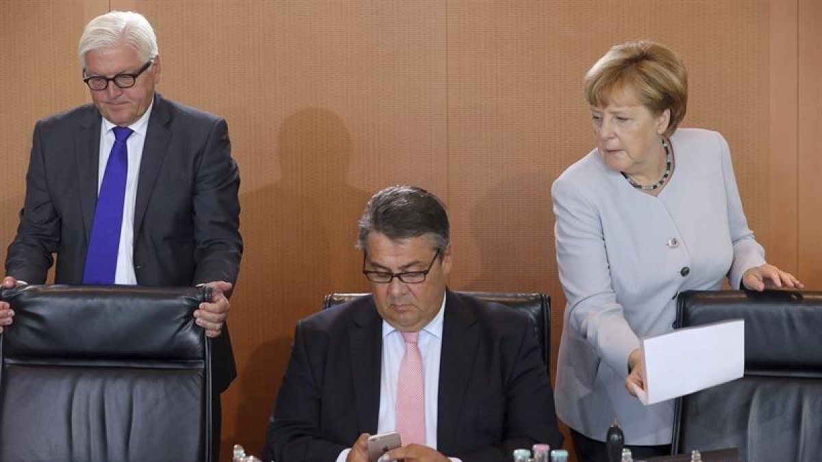 El ministro de Exteriores alemán, Frank-Walter Steinmeier (i), el ministro alemán de Economía, Sigmar Gabriel (c), y la canciller alemana, Angela Merkel (d), a su llegada a una reunión semanal del gabinete.-EFE