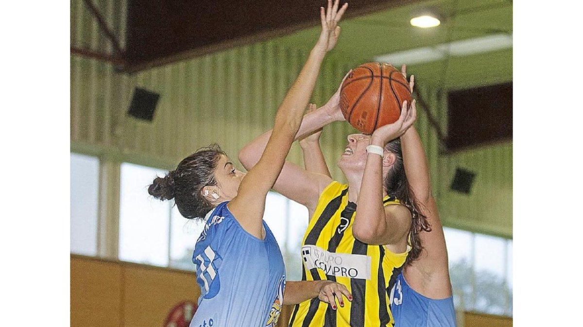Dos jugadoras de Filipenses intentan taponar a Cristina.-J.C. Castillo