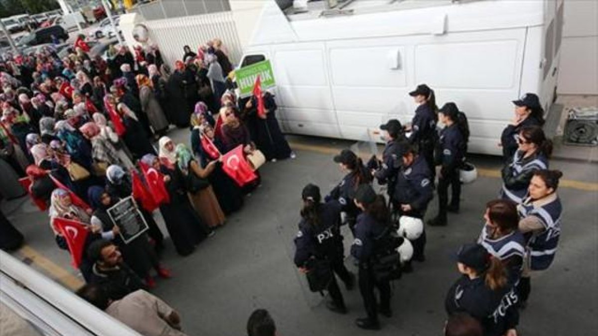 Mujeres policía vigilan a un grupo de manifestantes frente a la sede del hólding Koza Ipek, en Ankara.-AP