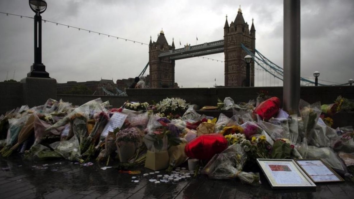 Varios ramos de flores, velas y mensajes dejados en memoria de las víctimas en los alrededores del Ayuntamiento en Londres, el 6 de junio-WILL OLIVER