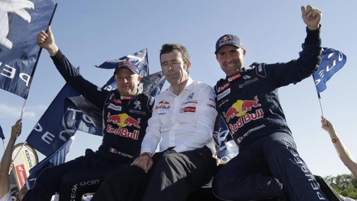 Stéphane Peterhansel, a la izquierda, junto al jefe de Peugeot, Bruno Famin, y su copiloto Jean Paul Cottret.-AP / MARTÍN MEJÍA