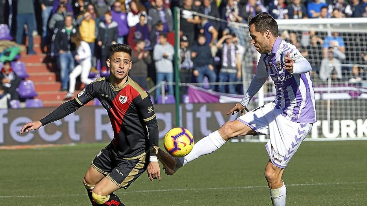 Míchel Herrero controla el esférico ante la presencia del jugador rayista Alex Moreno.-J. M. LOSTAU