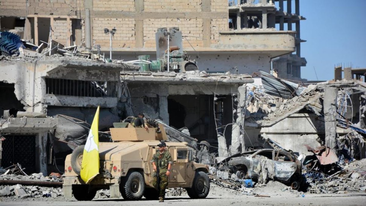 Combatientes de las Fuerzas de Siria Democratica vigilan el centro de la localidad siria de Al Raqa, el 18 de octubre de 2017.-EFE
