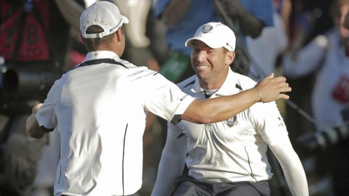 Sergio García abraza a Martin Kaymer tras embocar el alemán el putt definitivo en la Ryder del 2012.-AP / CHARLIE RIEDEL