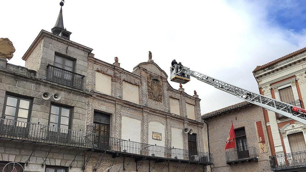 Los bomberos afianzan la escultura superior de la Casa de los Arcos.-EL MUNDO