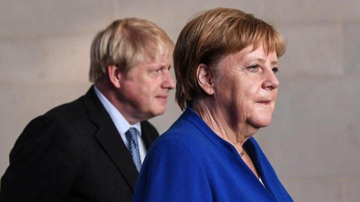 El primer ministro británico, Boris Johnson, y la cancillera alemana, Angela Merkel, en un encuentro en Berlín el pasado agosto.-FILIP SINGER (EFE)