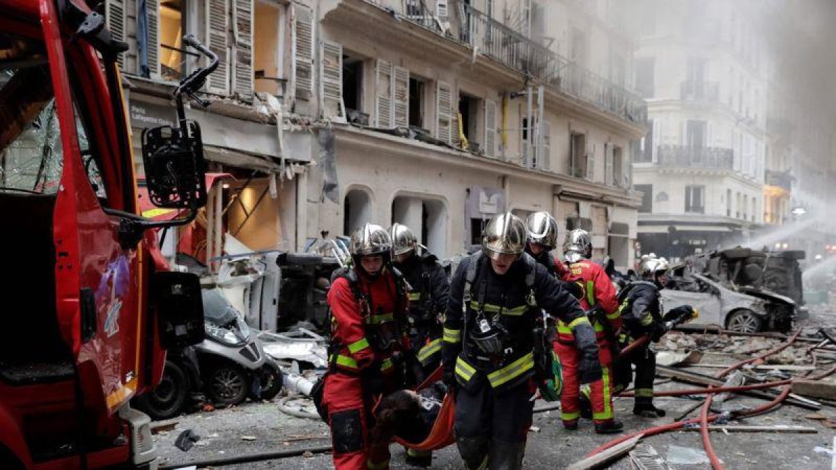 Los bomberos trasladan a una herida en la explosión en una panadería en París, este sábado.-AFP