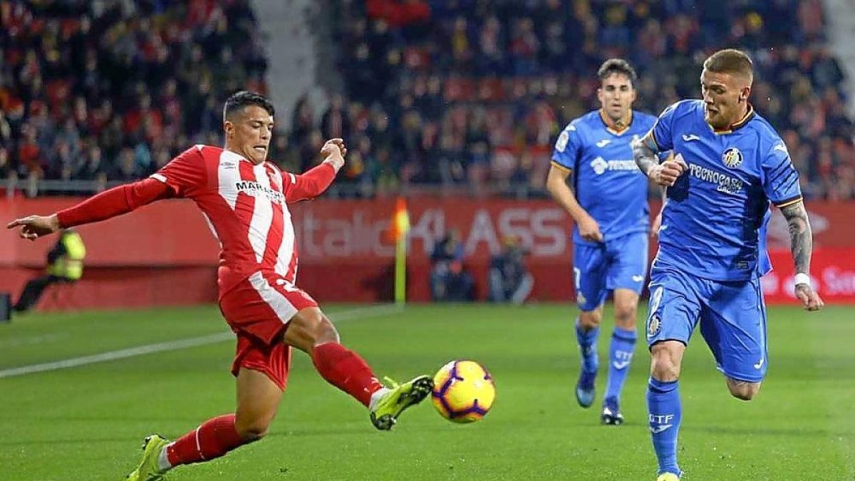Pedro Porro intenta levarse el balón ante la presencia de Antunes y Mata en el Girona-Getafe de la pasada temporada.-ANIOL RESCLOSA