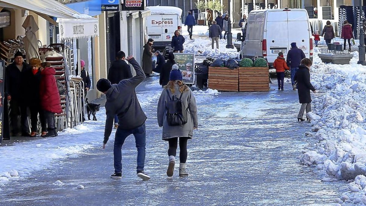 Un joven, a punto de resbalar a causa del hielo en el centro de Segovia, en la bajada de acceso al Acueducto.-ICAL