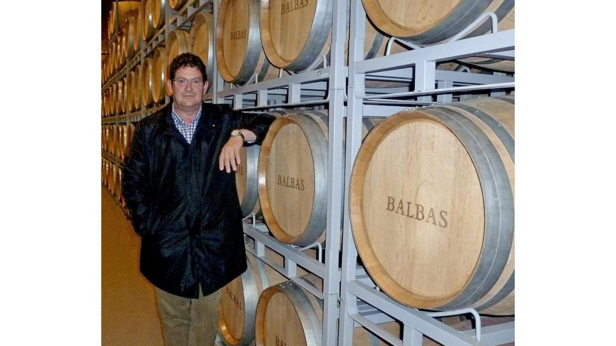 Juan Jose Balbás posa junto a unas barricas de su bodega, donde reposa el vino.-E.M.